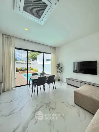Modern living room with pool view, sleek furniture, and marble flooring.