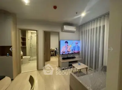 Modern living room with TV, air conditioning, and stylish decor in a cozy apartment setting.