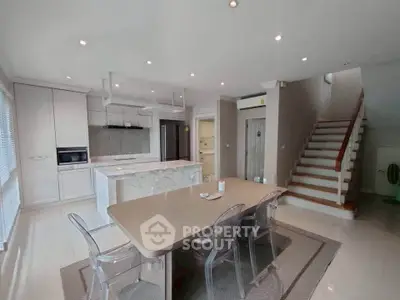 Spacious modern kitchen with island and dining area in elegant home
