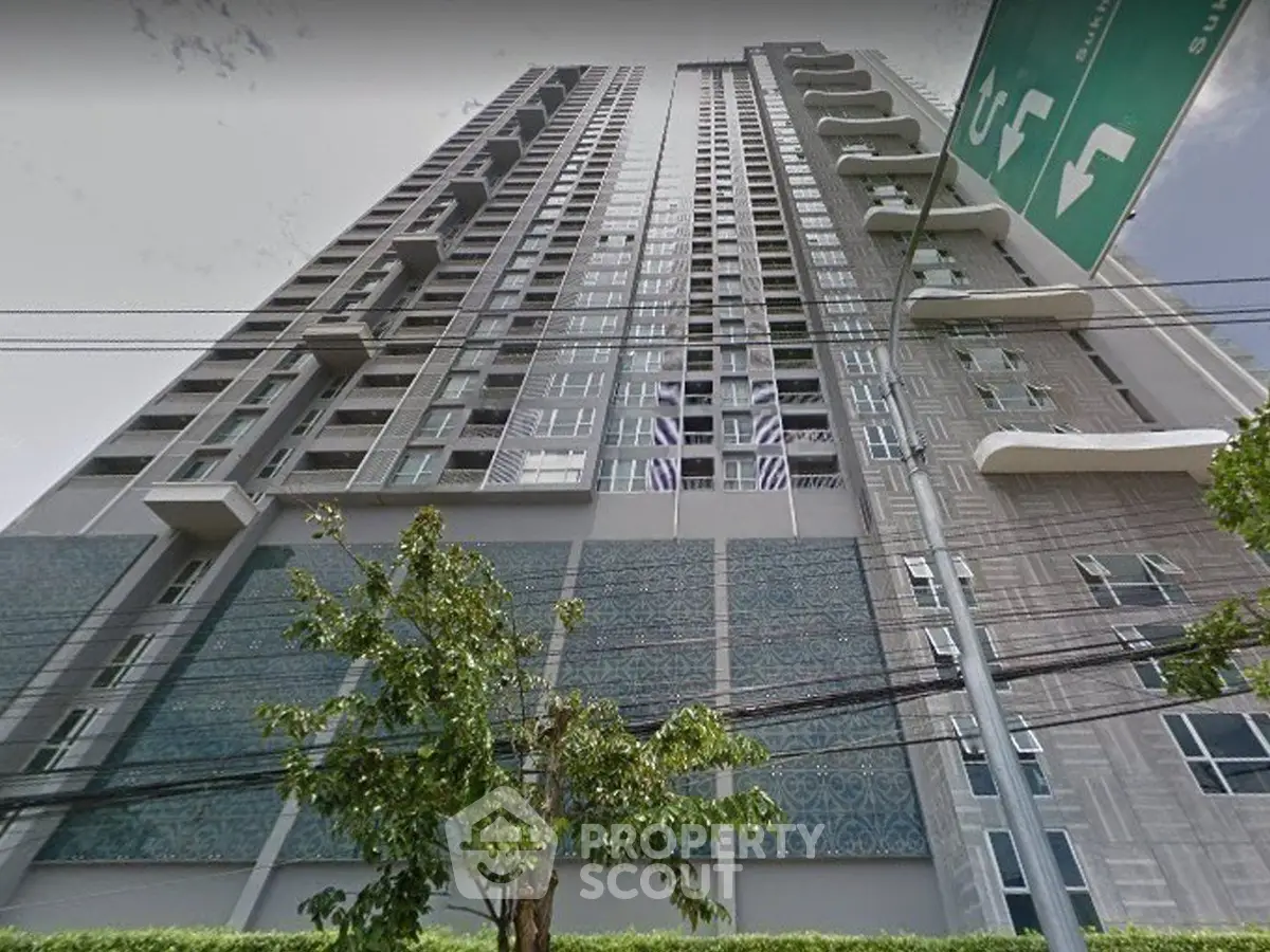 Stunning high-rise building with modern architecture and lush greenery at the base, perfect for urban living.