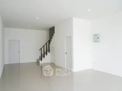 Spacious minimalist interior with sleek staircase and glossy tiled floor, perfect for modern living.
