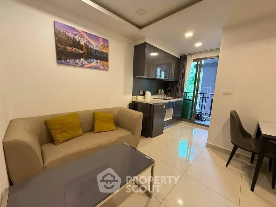 Modern living room with cozy sofa, sleek kitchen, and balcony view in stylish apartment.