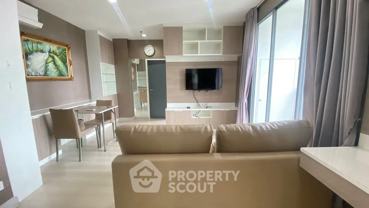 Modern living room with stylish furniture and wall-mounted TV in a cozy apartment.