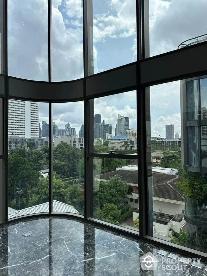 Stunning cityscape view from modern high-rise building with floor-to-ceiling windows.