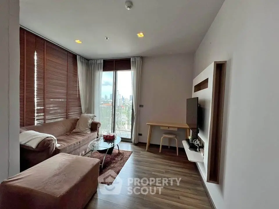 Modern living room with city view, featuring cozy seating and sleek decor.
