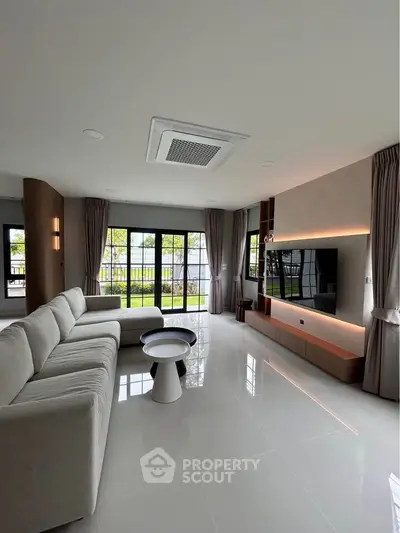 Spacious modern living room with large windows and sleek furniture