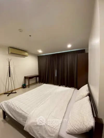 Spacious bedroom with modern furnishings and natural light