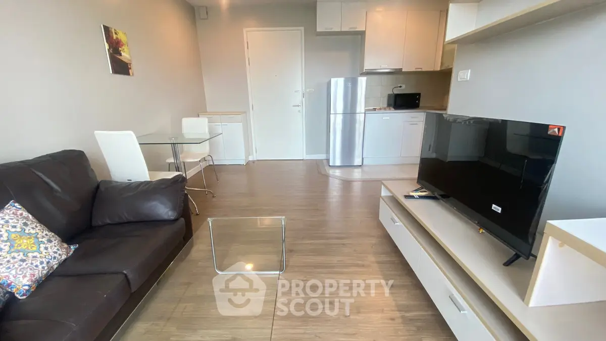 Modern living room with sleek furniture and open kitchen layout, perfect for urban living.