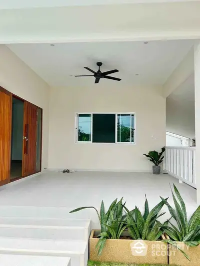 Spacious modern entrance with ceiling fan and lush greenery