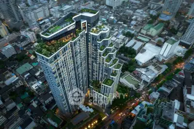 Stunning aerial view of modern high-rise building with lush rooftop gardens in bustling cityscape.