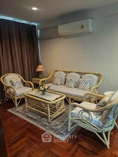 Charming living room with elegant rattan furniture and cozy ambiance, perfect for relaxation.