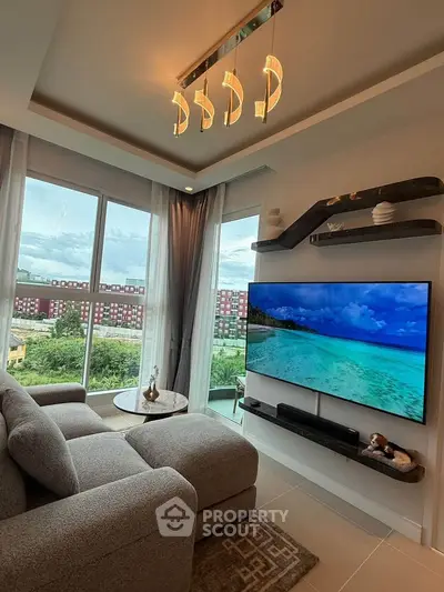 Modern living room with large windows and scenic view, featuring a cozy sofa and wall-mounted TV.