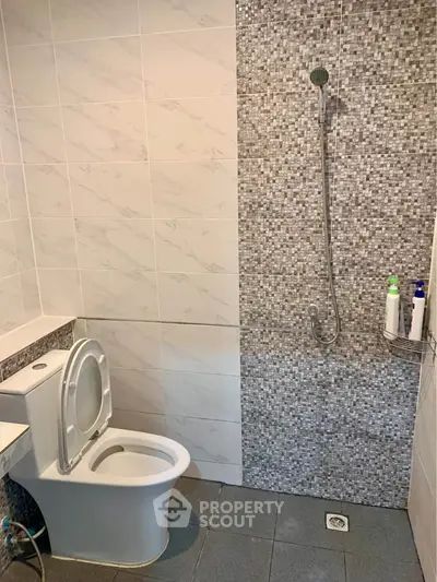 Modern bathroom with sleek tile design and open shower layout.