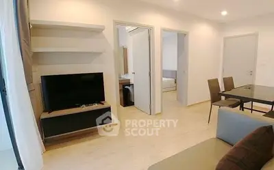 Modern living room with TV and dining area in open layout apartment.