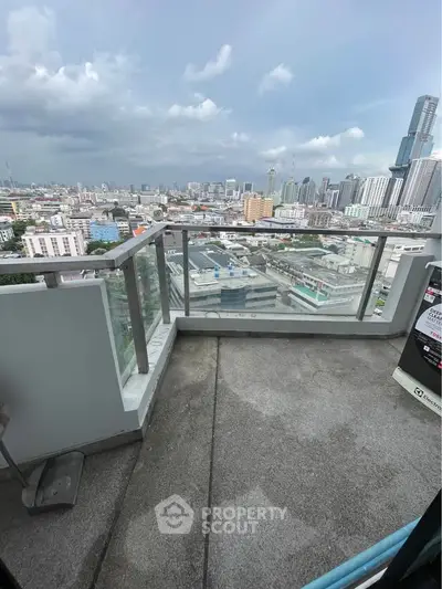 Stunning cityscape view from a high-rise balcony with glass railing, perfect for urban living.