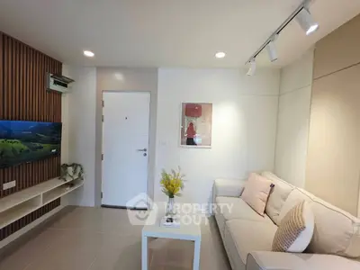 Modern living room with cozy sofa and wall-mounted TV in stylish apartment