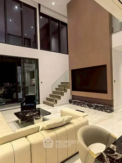 Luxurious modern living room with high ceilings and elegant staircase
