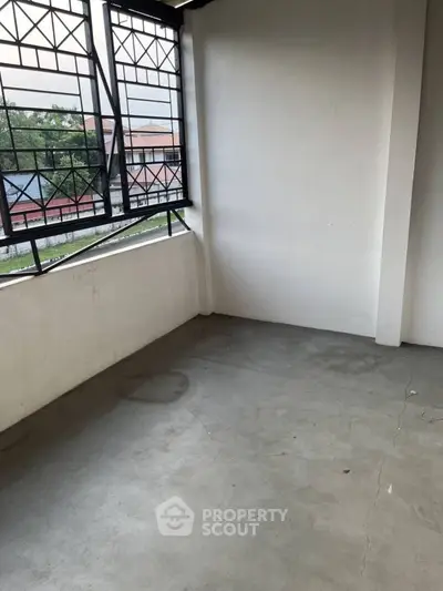 Spacious balcony with metal railings and concrete floor, ideal for relaxation and outdoor activities.