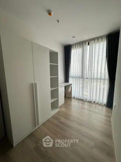 Bright study room with large window and modern furniture, perfect for productivity.