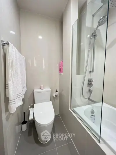 Modern bathroom with sleek design, featuring a bathtub and shower combination.