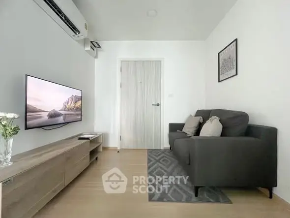 Modern living room with sleek furniture and wall-mounted TV