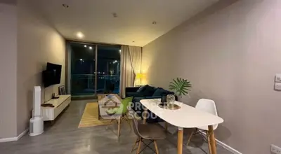 Modern living room with stylish furniture and ambient lighting, featuring a cozy seating area and dining table.