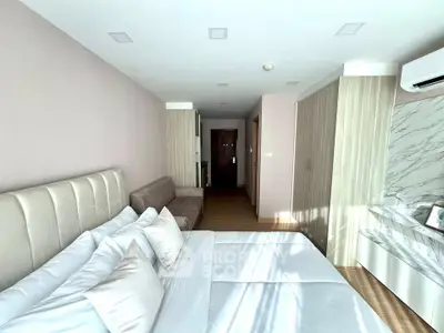Modern bedroom with stylish decor and natural light, featuring a comfortable bed and sleek furnishings.