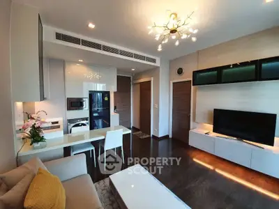 Modern living room with sleek furniture and open kitchen layout, featuring elegant lighting and stylish decor.