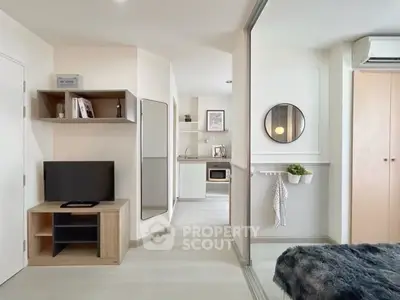 Modern studio apartment with open layout and stylish decor, featuring a cozy living area and compact kitchen.