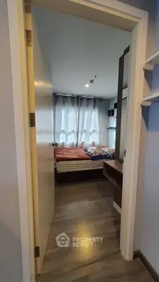 Cozy bedroom with modern decor and ample natural light through large window.