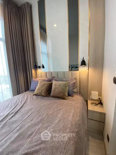 Luxurious bedroom with elegant decor and large window offering natural light.