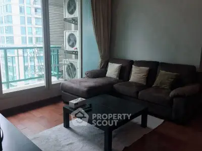 Modern living room with large windows and comfortable sofa in high-rise apartment.