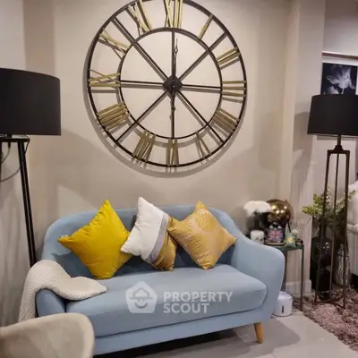 Chic living room with stylish blue sofa and decorative wall clock