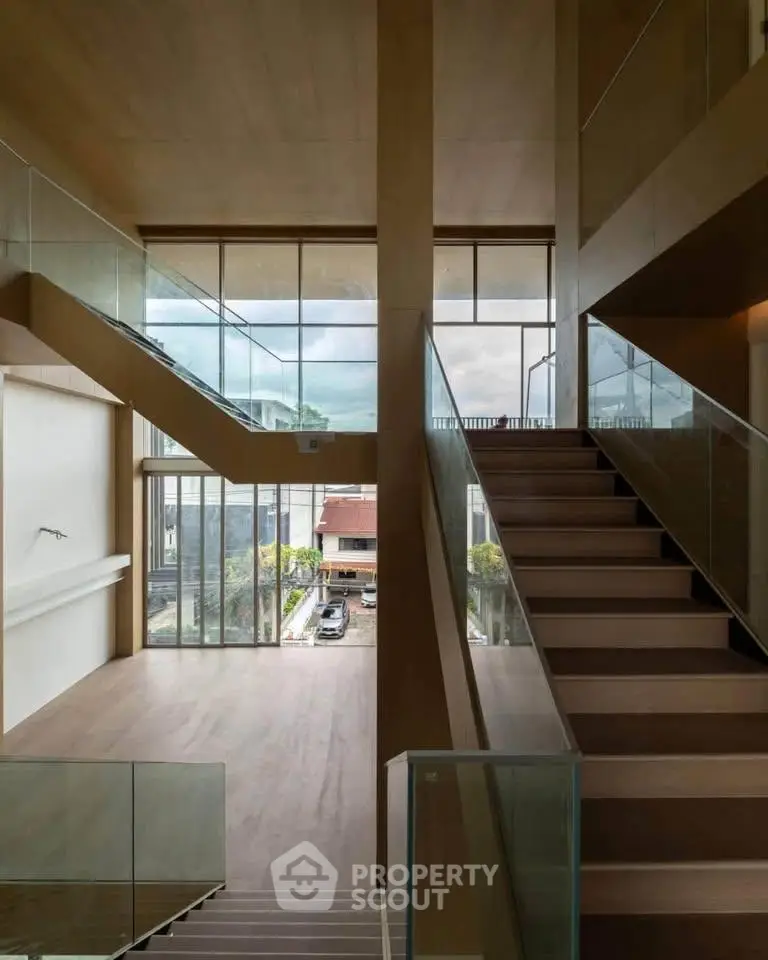 Modern multi-level interior with large windows and wooden finishes, showcasing a spacious and elegant design.