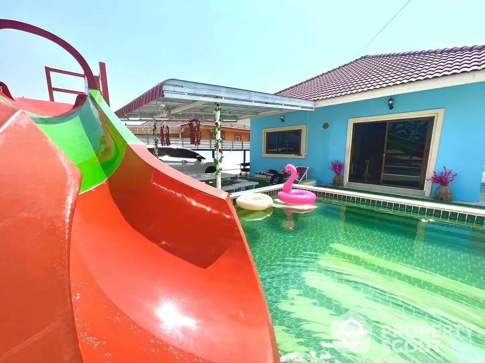 Vibrant poolside with colorful slide and inflatable toys at a modern home