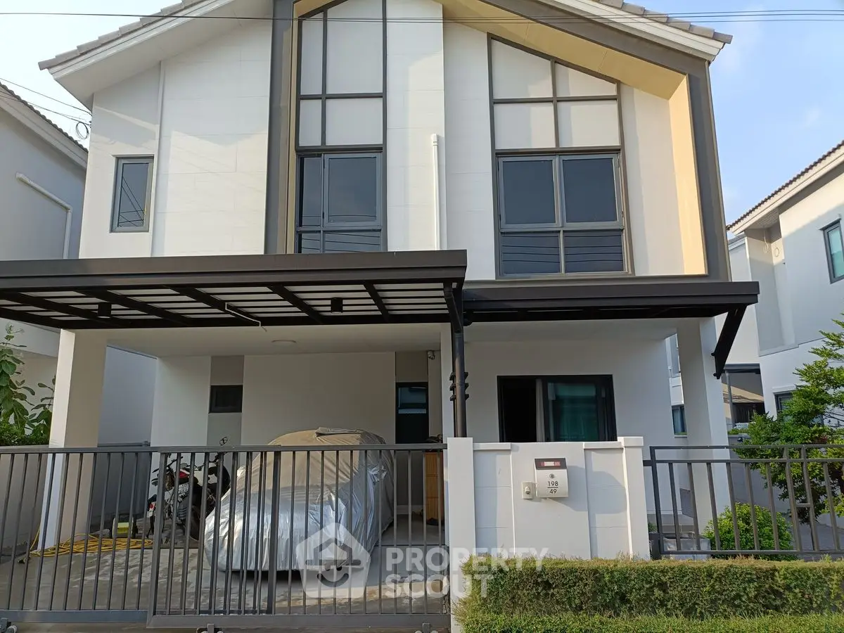 Modern two-story house with covered parking and sleek exterior design.