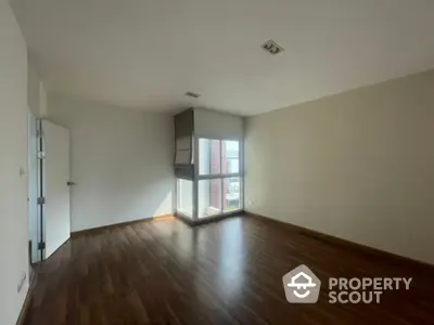 Spacious and well-lit corner unit living room with polished hardwood floors and large windows offering ample natural light, perfect for a modern lifestyle.