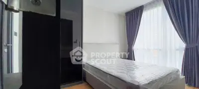 Modern bedroom with large window and elegant curtains, featuring a comfortable bed and sleek design.