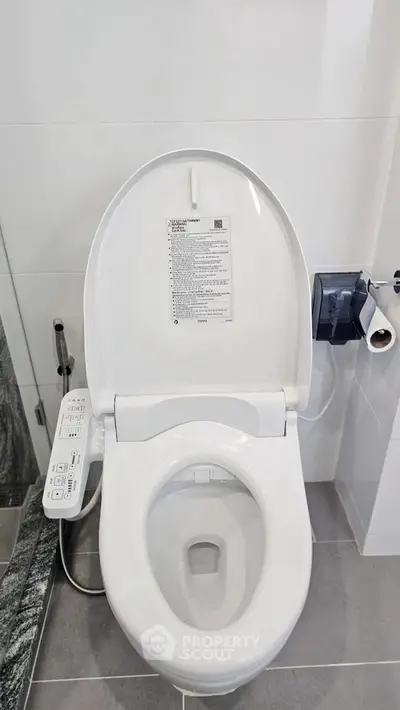 Modern bathroom with high-tech bidet toilet and sleek design.