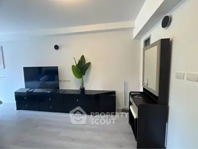 Modern living room with sleek black furniture and large TV