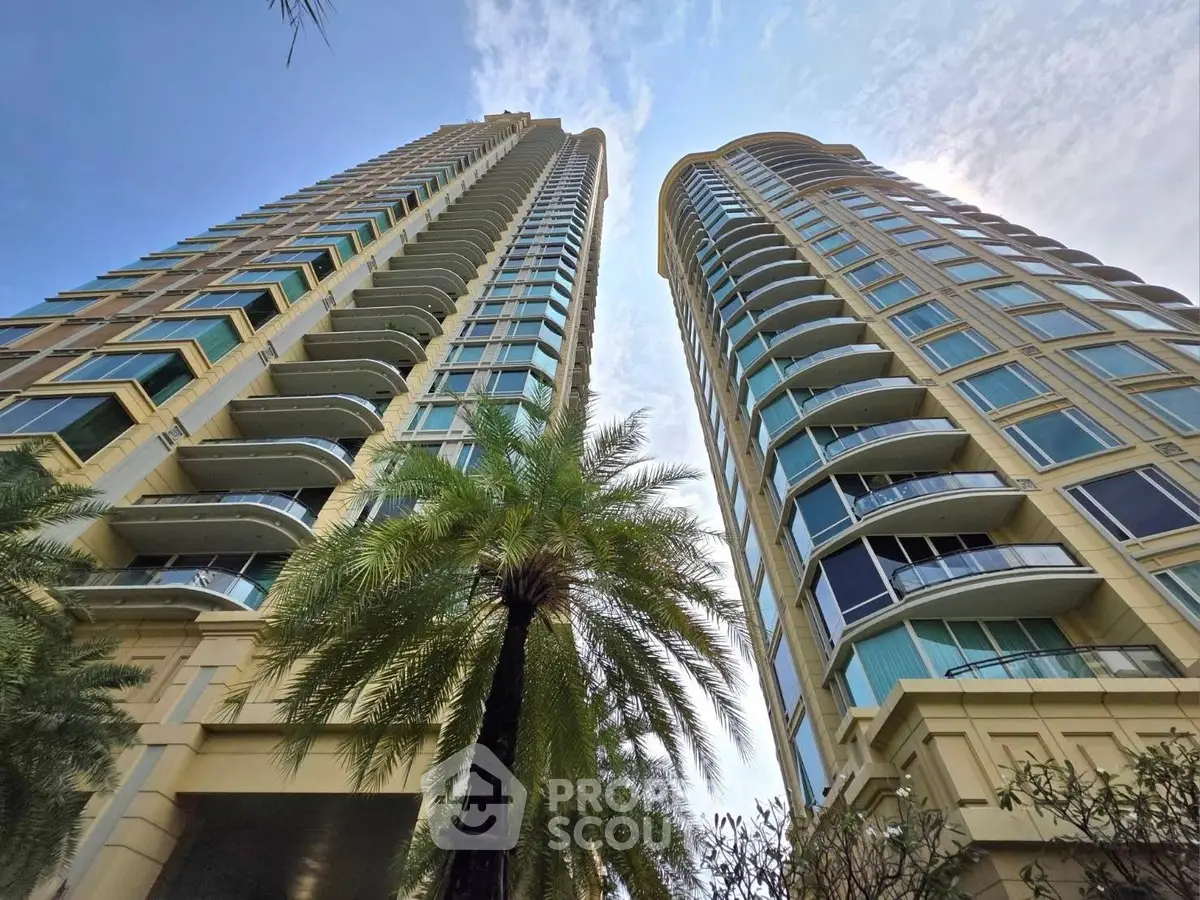 Stunning view of modern high-rise buildings with lush palm trees and clear blue sky.
