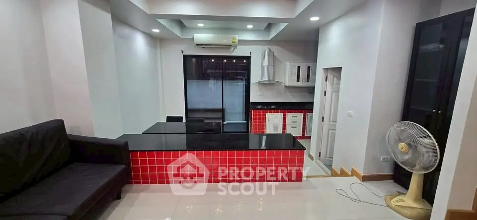 Modern kitchen with red tile accents and open layout