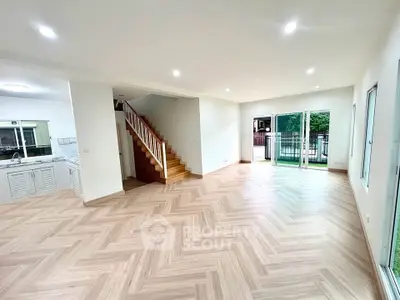 Spacious open-plan living room with wooden flooring and garden view
