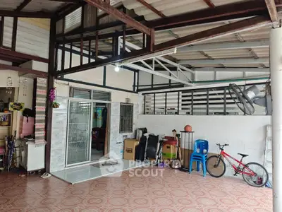 Spacious covered outdoor area with tiled flooring and storage space.