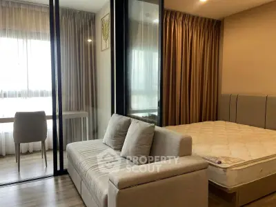Modern studio apartment with cozy living area and bedroom, featuring elegant curtains and natural light.
