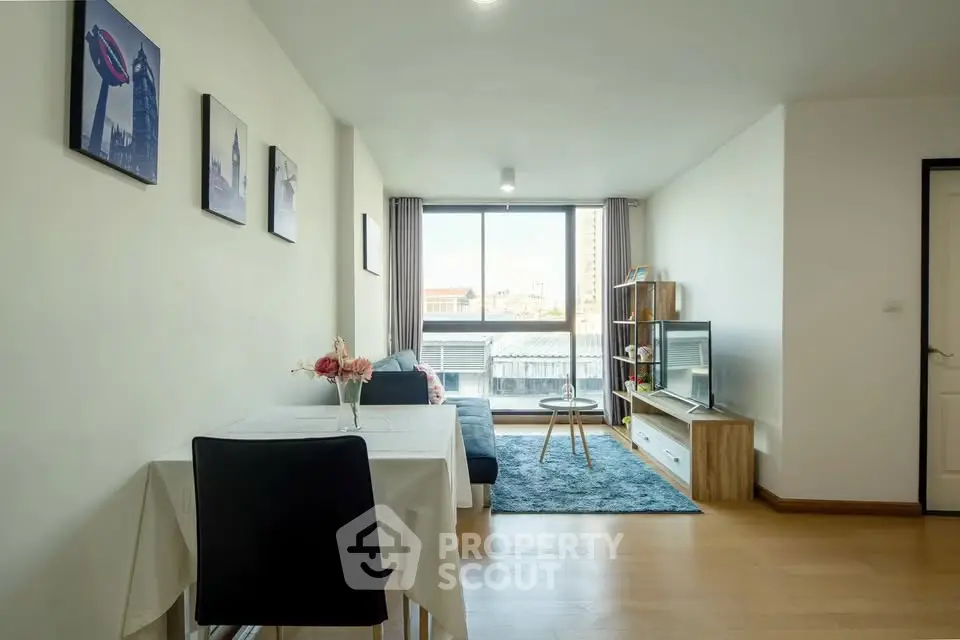 Modern living room with stylish decor and large window offering natural light.