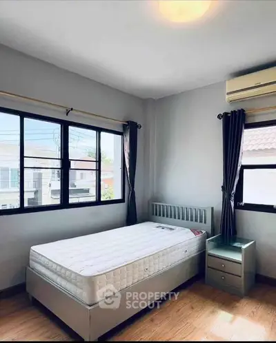 Bright bedroom with large windows and modern furnishings in a stylish apartment.
