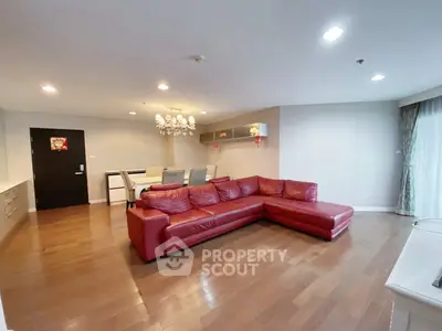 Spacious living room with red leather sectional and elegant dining area