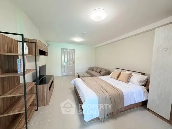 Spacious bedroom with modern decor and cozy seating area