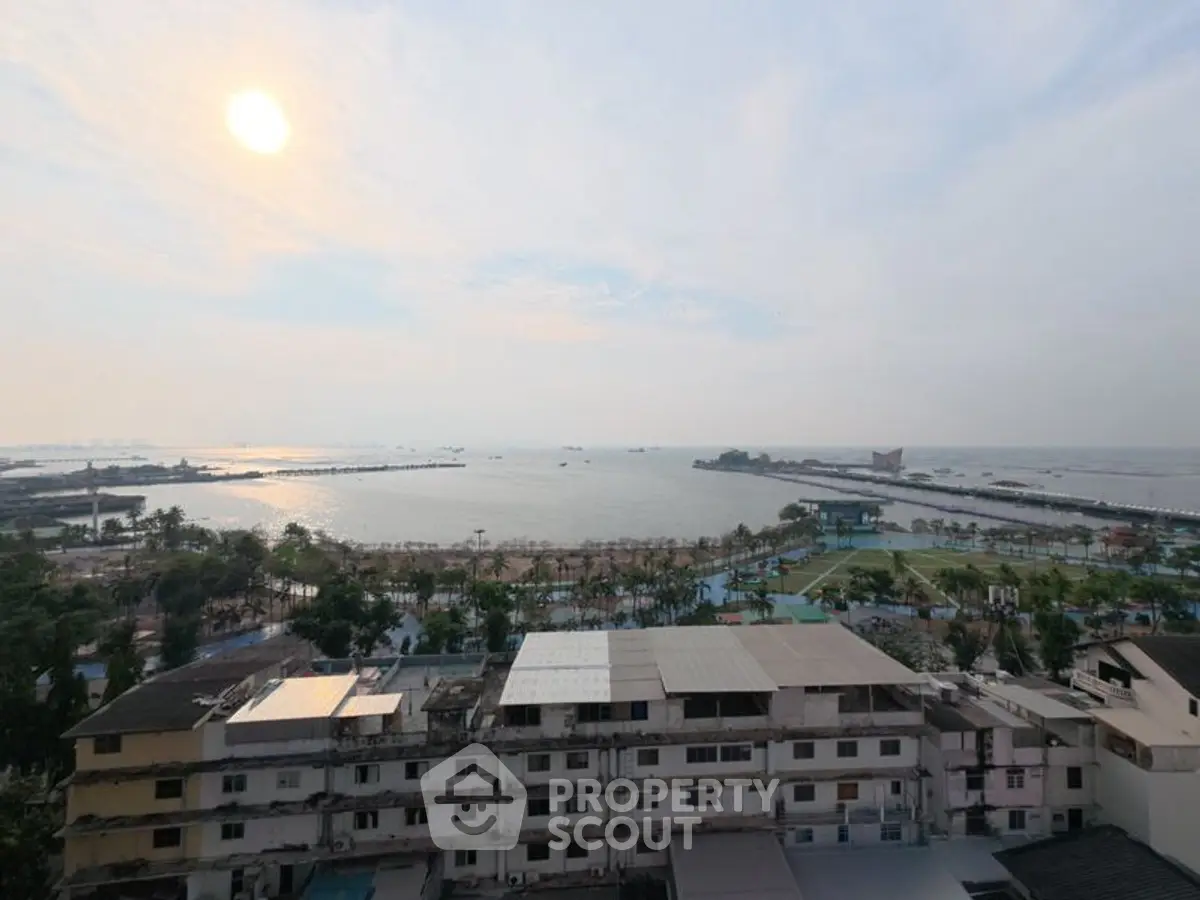 Stunning ocean view from high-rise building overlooking lush greenery and cityscape.